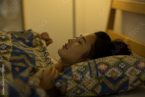 ベッドで眠る若い女性
