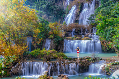 Tourist woman in swimming suit at Thi Lo Su Waterfall in National Park in Thailand.