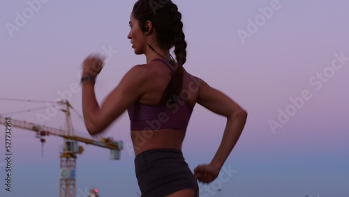 Energy, speed and fitness training by athlete running at sunset, serious and focus on health goals. Young woman doing an intense cardio run, practice endurance and strength, tough physical challenge