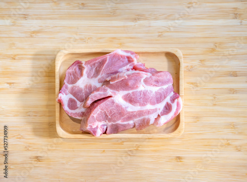 Flatlay Topview Raw Pork is prepared for Cook, It is on wood plate in studio light with Chef hand background. Clipping Paths. photo