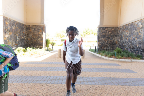 African american elementary schoolboy running for school