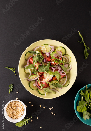 Overhead view of healthy salad in bowl on black background with copy space