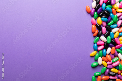 Directly above view of colorful sweet candies by copy space on purple background