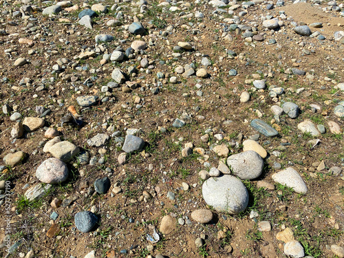 Fotografi rocky stone pebble beach low tide shore ocean water edge wet rainy riverbed sand