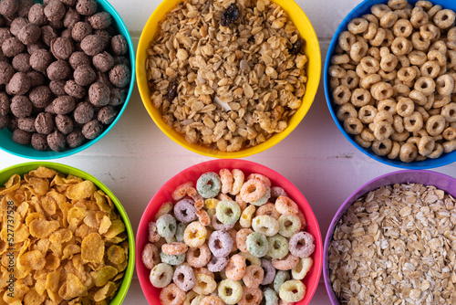 Full frame shot of various breakfast cereals in colorful bowls arranged on table with copy space