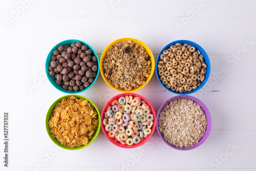 Directly above shot of different breakfast cereals in colorful bowls arranged on table