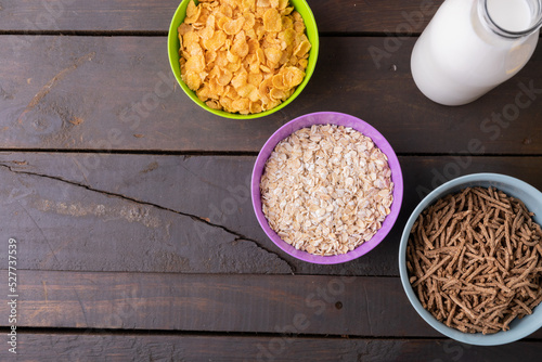 Directly above shot breakfast cereals in bowl by milk on wooden table