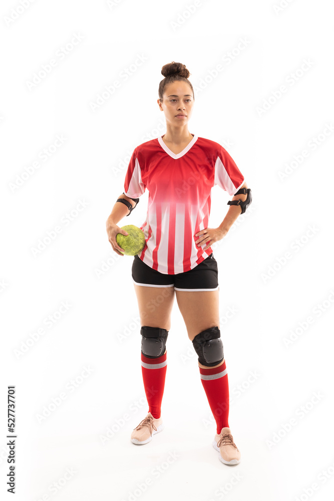 Full length of biracial young female player with handball standing against white background