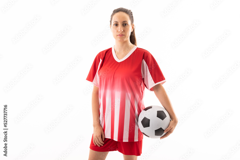 Portrait of caucasian young female soccer player with ball standing against white background
