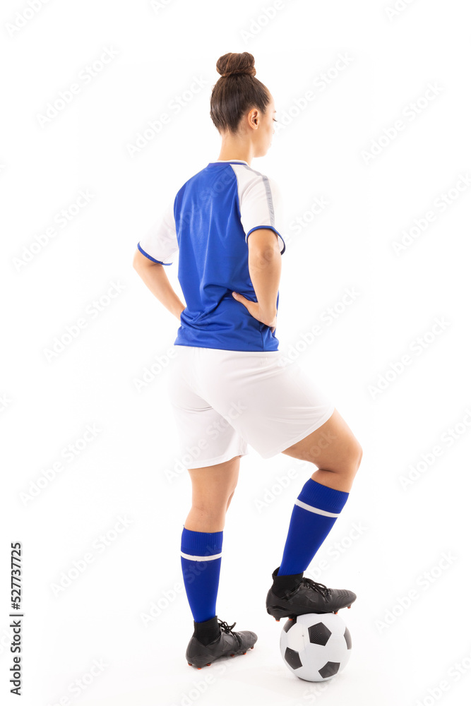 Full length of biracial young female player with hand on hip and standing with foot on soccer ball Full length of biracial young female player with hand on hip and standing with foot on soccer ball