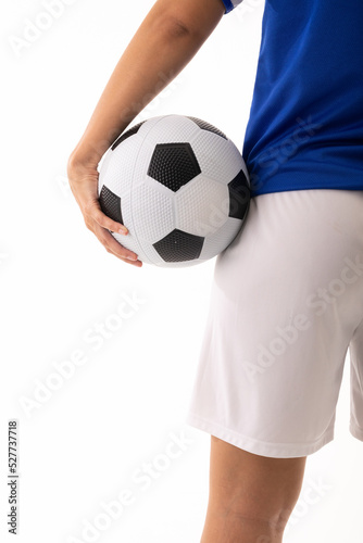 Close-up midsection of biracial young female soccer player holding ball against white background