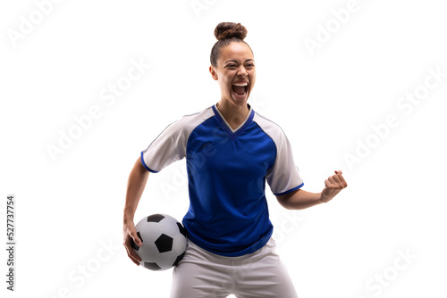 Biracial young female player shouting while standing with clenched fist and soccer ball