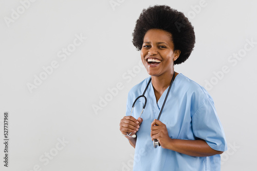 Portrait of cheerful african american mid adult female doctor against white background, copy space
