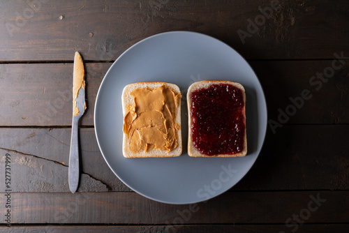 Directly above shot of open face peanut butter and jelly sandwich in plate on table with table knife
