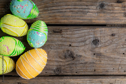 Close-up of decorated colorful easter eggs on wooden table with empty space