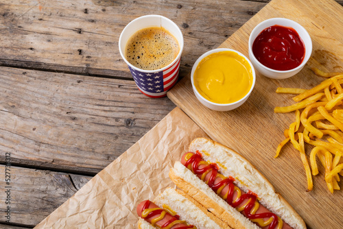 Close-up of hot dogs with french fries and sauces by drink on table