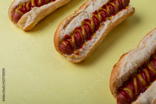 High angle view of sausages arranged in a row on yellow background