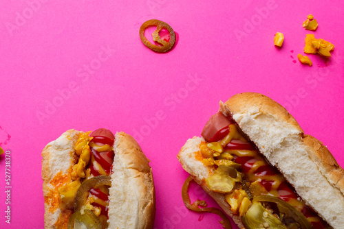 Overhead close-up of hot dogs on pink background