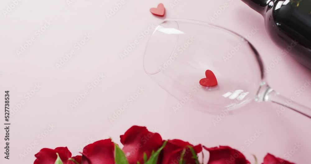 Red roses and wine glass with bottle on pink background at valentine's day Red roses and wine glass with bottle on pink background at valentine's day