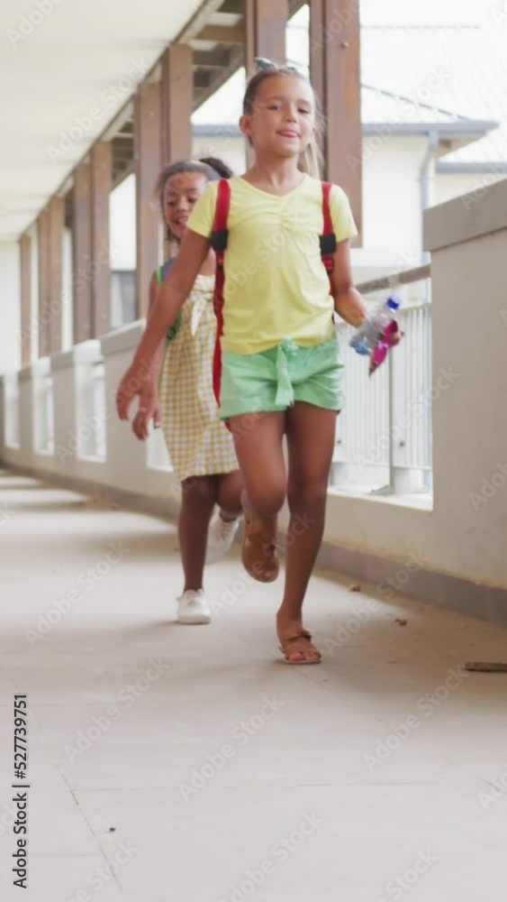 Video of happy diverse girls running at school corridor and talking Video of happy diverse girls running at school corridor and talking