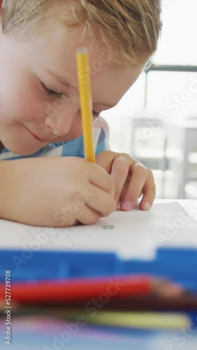 Wallpaper Mural Video of happy caucasian boy sitting at school desk and writing Torontodigital.ca