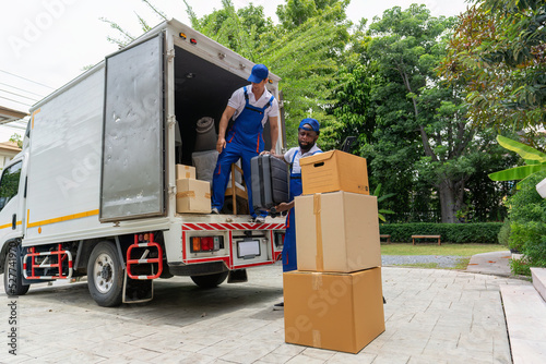 Professional goods move service use truck carry personal belongings door to door transport delivery handover boxes luggage one by one and keep stack on the floor before transfer to place in house
 photo