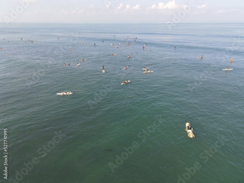 Aerial view of people surfing on waves with surfboards when vacation in Bali, Indonesia