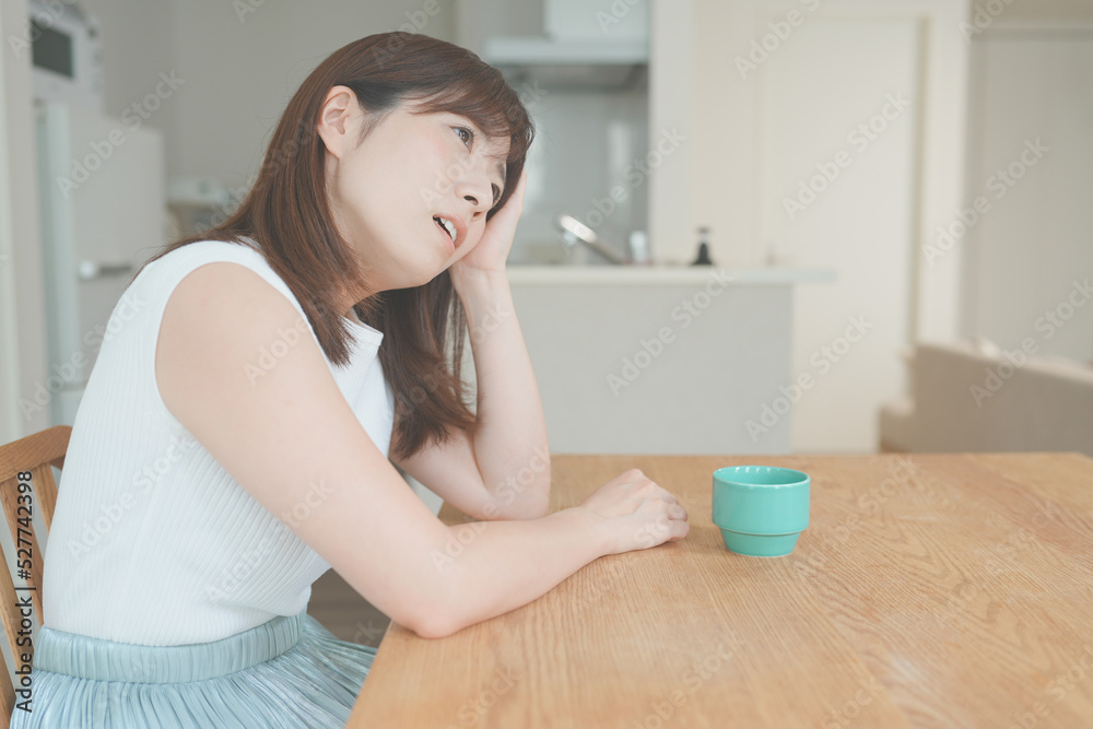 リビングでひとり悩む若い女性 リビングでひとり悩む若い女性