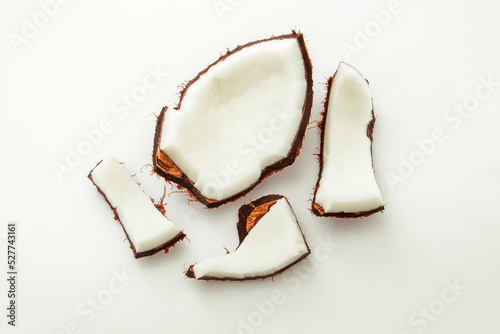 Ripe coconuts chapped on white paper background, top view , flat lay