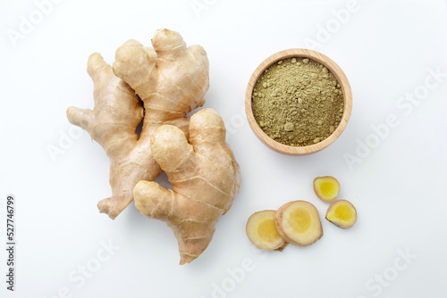 Fresh ginger slice with ginger powder in wooden bowl on white paper background , top view , flat lay.