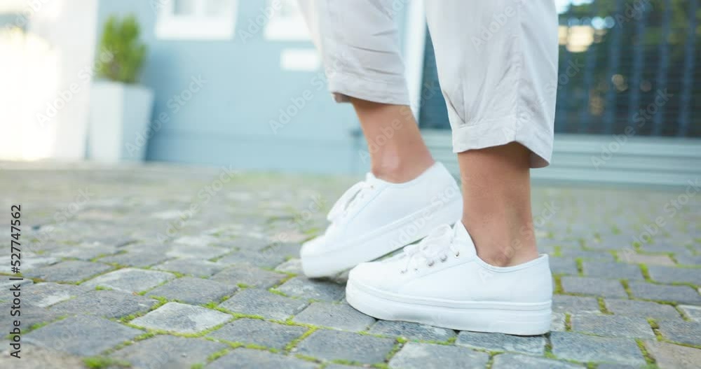 Shoes, dance and music with feet of a woman dancer moving and dancing on a sidewalk or pavement outside of her home. Stepping, tapping and choreography with footwork, rhythm and routine outdoors