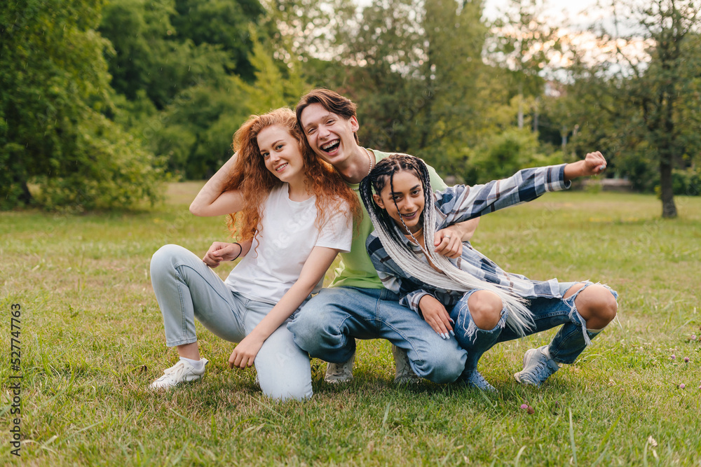 Caucasian bloggers enjoying funny moment while posing in the city park, relaxing surrounded by green nature. Young people community, group. Happy girls friends Caucasian bloggers enjoying funny moment while posing in the city park, relaxing surrounded by green nature. Young people community, group. Happy girls friends
