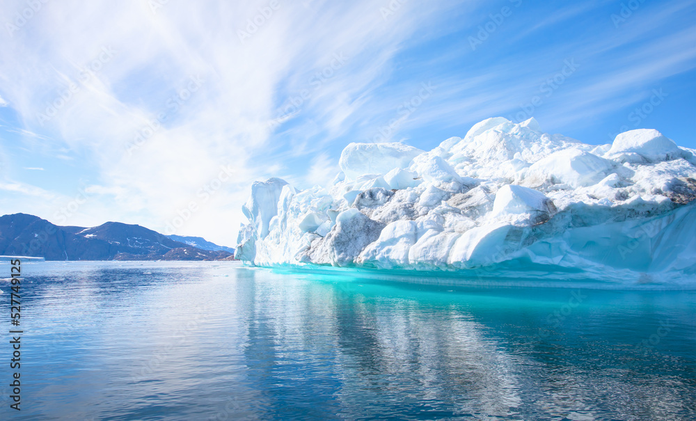 Fototapeta premium Melting icebergs by the coast of Greenland, on a beautiful summer day - Melting of a iceberg and pouring water into the sea - Greenland
