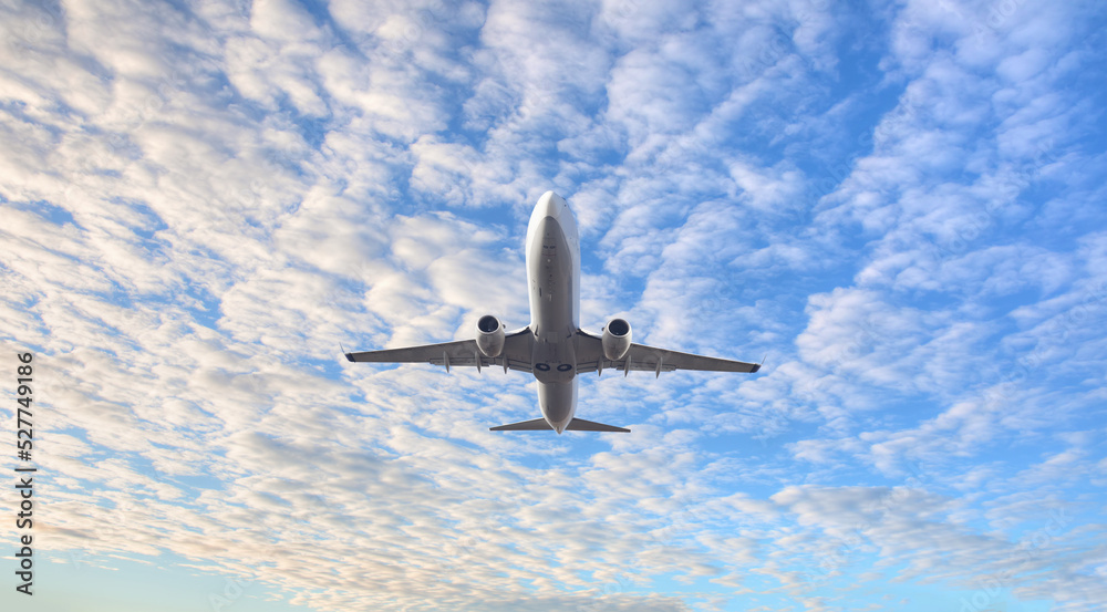 Obraz premium White passenger airplane flying in the sky amazing clouds in the background - Travel by air transport