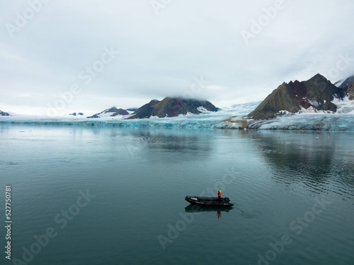 Spectacular view of the glacier with icebergs and Zodiac tourist boats in the foreground. Samarinbreen Glacier. Estuary into the Hornsundfjord, Spitsbergen island photo