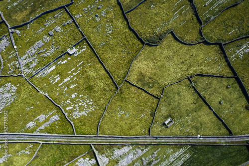 Green grass fields between stone fences of walls. Aerial top down view on meadow. Irish landscape. Aran Island, county Galway, Ireland. Popular and famous travel area. photo