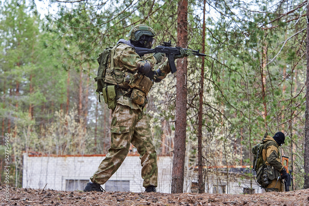 Fototapeta premium a man in the forest shoots from a machine gun