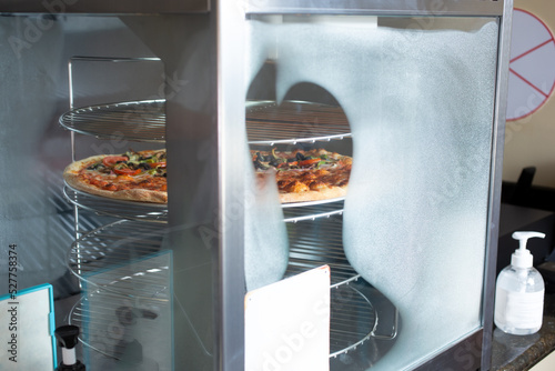 Photography A view of a pizza inside a pizza warming appliance, seen at a local restaurant