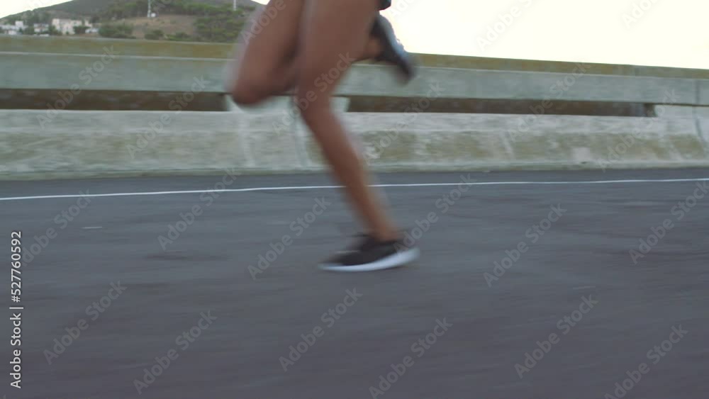 Running, shoes and fitness with a woman runner in the city for workout, exercise and health. Feet, legs and fast with a female athlete taking a run and training for sports, wellness and cardio
