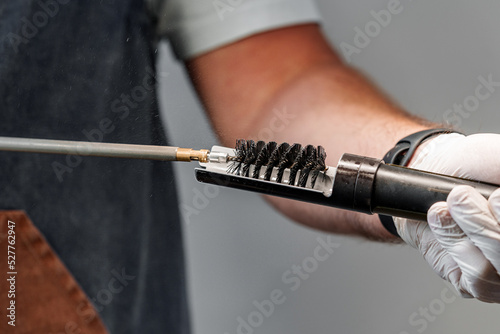 Close up of a gunsmith cleaning firearm barrel with ramrod brush