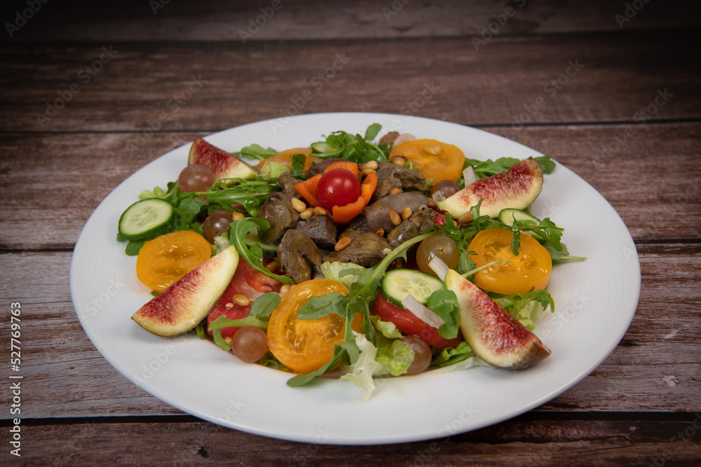 Recipe for fried chicken liver and gizzards with salad and tomatoes, cucumber, figs, grapes on a white plate, High quality photo Recipe for fried chicken liver and gizzards with salad and tomatoes, cucumber, figs, grapes on a white plate, High quality photo