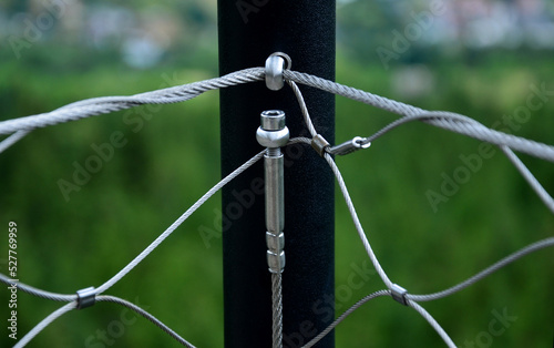 Terrace fencing  railings of metal pipes filled with steel cables cable mesh. fencing wire stainless steel fence. wooden floor  dance floor in the park  tech  cable  screw  eyelet