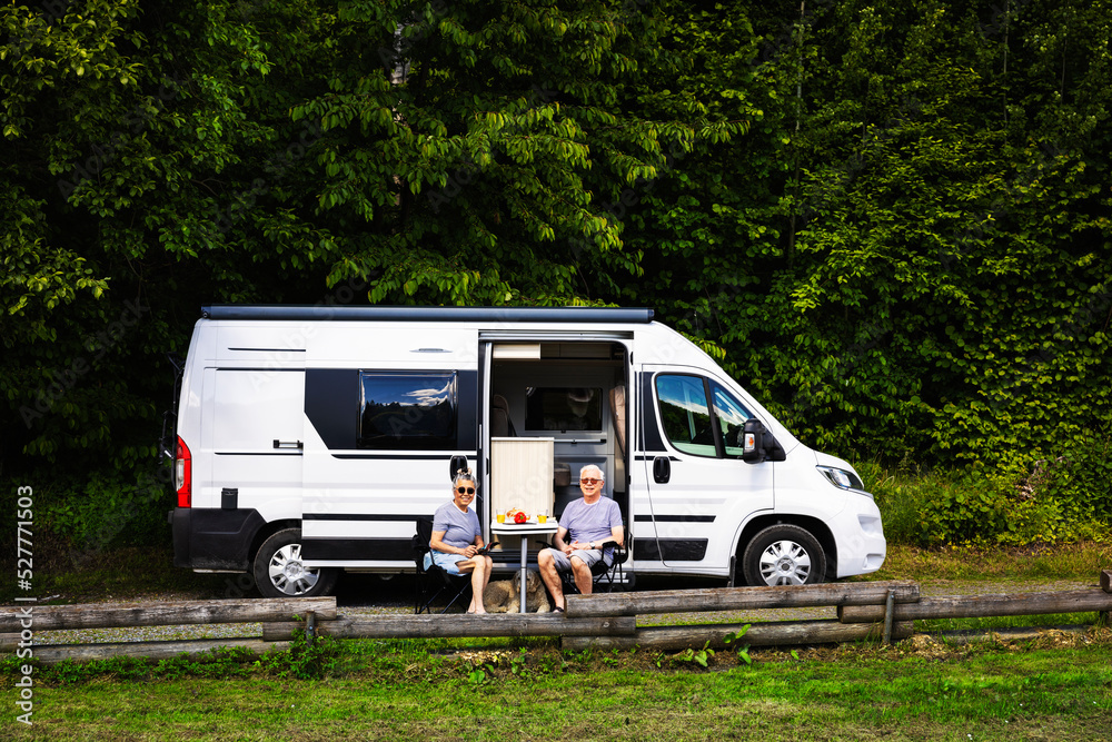Senior couple sitting in front of trailer Senior couple sitting in front of trailer