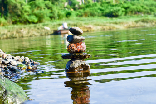 A stone pyramid in the water by the river, the concept of harmony and balance