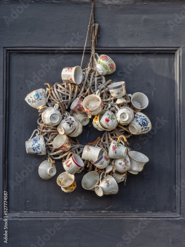 Cups attached to a wreath hanging from a door photo