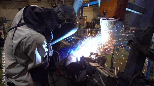 Man welding car parts assembly, man welding work piece in production line, Male welds the automotive part in car factory