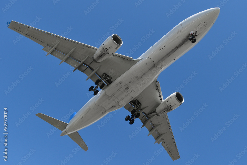 Obraz premium vista inferior del fuselaje de un avion comercial aterrizando