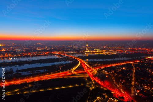 Vienna evening panorama . Illuminated Vienna city and Danube river . Urban infrastructure aerial night view 
