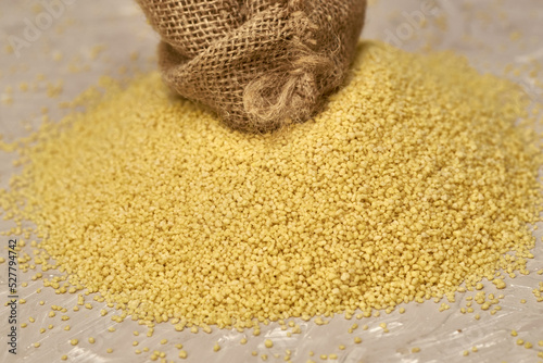 Tableau sur toile croup couscous poured out of a canvas bag on the table