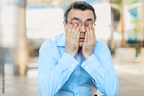 Burned out businessman covering face with hands